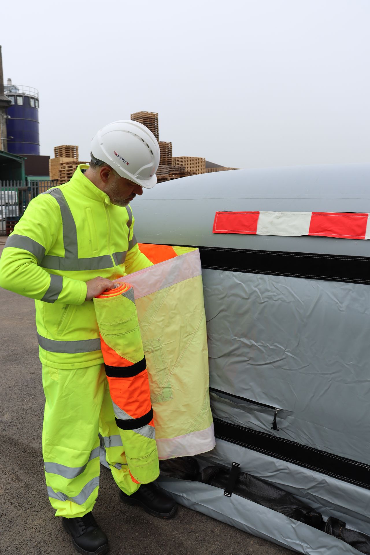 Operative attaching a high-visibility reflective chevron panel to the front of an inflated InflatorShield unit